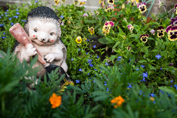 garden sculpture hedgehog with a guitar in flowers