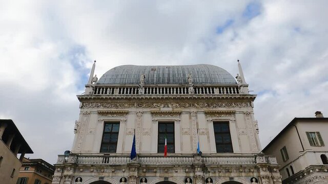 Comune di Brescia - City or town hall of Brescia, Lombardy, Italy. Round roof of an Italian building with white walls, windows, sculptures, Flags of EU and Italy. Architecture. Heritage.