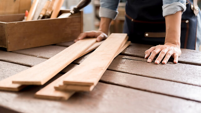 Carpenter working with equipment on wooden table in carpentry shop. woman works in a carpentry shop.