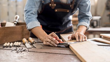 Carpenter working with equipment on wooden table in carpentry shop. woman works in a carpentry shop.