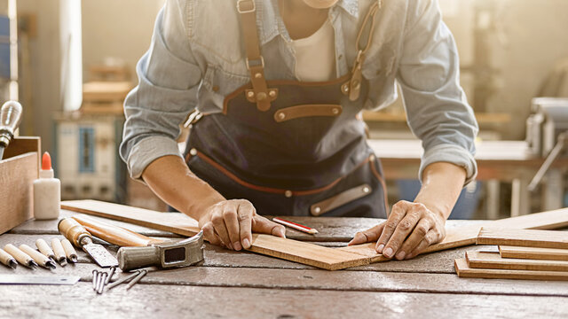 Carpenter working with equipment on wooden table in carpentry shop. woman works in a carpentry shop.