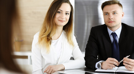 Business woman headshot at workplace in modern office. Unknown businesswoman sitting behind computer monitor. Young accountant or secretary looks good