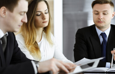 Fototapeta premium Business people or lawyers discussing questions at meeting in modern office. Unknown businessman and woman with colleague sitting and working at the glass desk. Teamwork and partnership concept