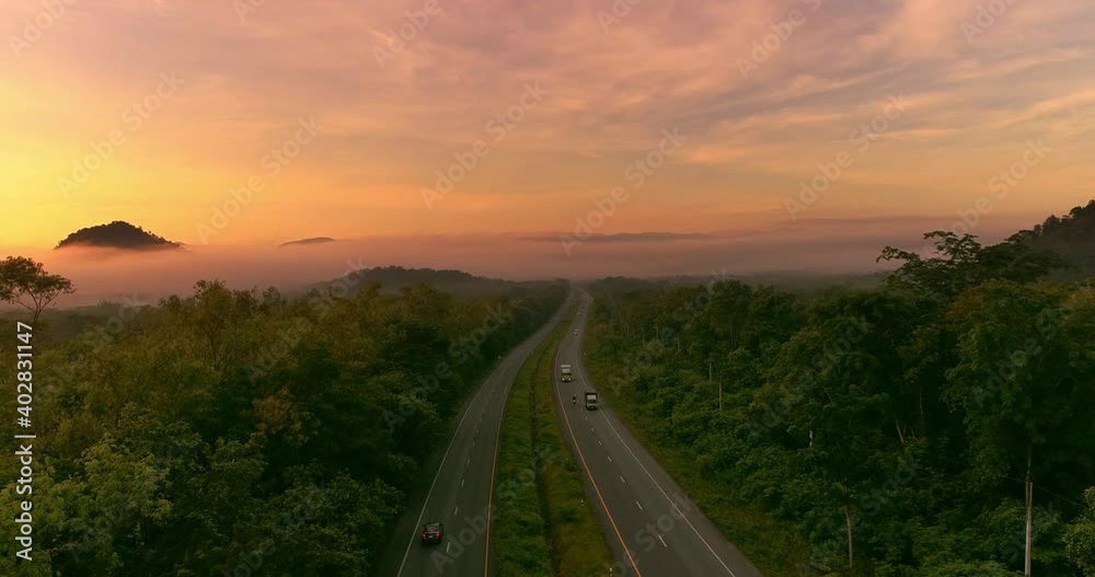 Wall mural Wide Shot Car driving on Mountain road and Sunset countryside,  Establishing shot.