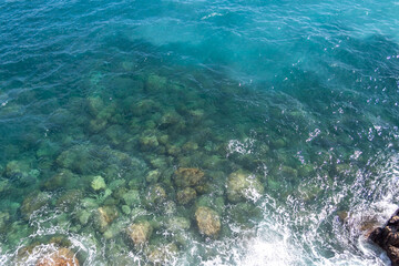 Rocky coastline on Amalfi. Sea surface with rocks and a boat.