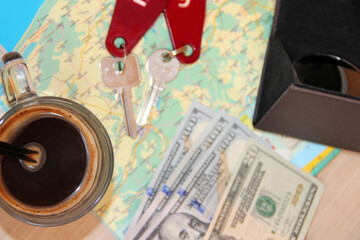 Passports sunglasses money and room keys number on map. Travel concept. Cup of coffee before trip