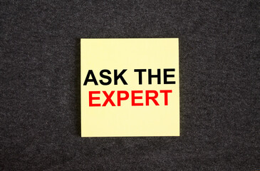 Yellow sticker on the dark gray texture background with text Ask The Expert