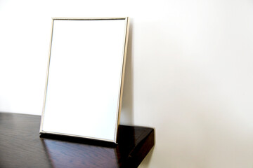 Empty photo frames standing at the wooden fireplace