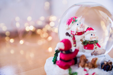 Snow globe Christmas home decoration with snowman. Bokeh background with lights