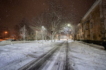 Cold winter night. Winter urban landscape. Snowfall.