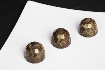 row of chocolate truffles with golden shimmer