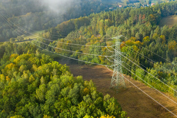 Aerial view of the high voltage power lines and high voltage electric transmission on the terrain...