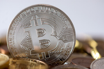 Bitcoin argenté debout parmi de nombreuses pièces floues. Le Bitcoin est une crypto-monnaie décentralisée sans banque centrale ni administrateur unique, qui utilise la technologie blockchain