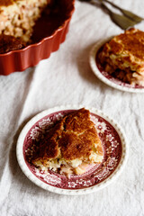 Apple and Cheese Cobbler Crisp. Cobbler or Crumble dessert with apples in ceramic baking form on beige linen table. Selective focus