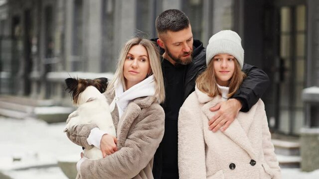 beautiful family with dog Papillon on street. photo shoot backstage