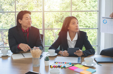 Brainstorm with business colleagues.Asian business woman holds tablet with her business team in the office.