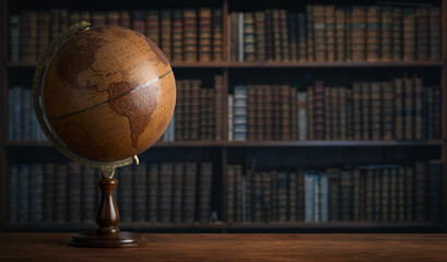 Old geographic globe in the cabinet against the background of bookselfs.Science, education, travel,...