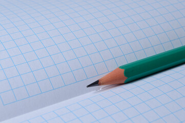 pencil lies on an open notebook. close-up.
