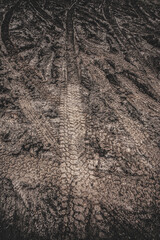 Tyre track on dirt sand or mud, Picture in retro or grunge tone. Car drive on sand. off road track. Track on grass field. Track in farm.