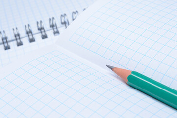 pencil lies on an open notebook. close-up.