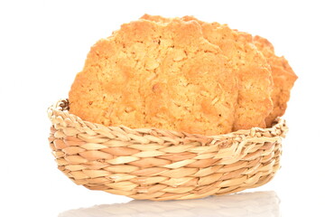 Several delicious torchetti cookies with oatmeal in a straw plate, close-up, isolated on white.