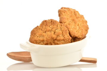 Several delicious torchetti cookies with oatmeal and white ceramic dishes, close-up, isolated on white.
