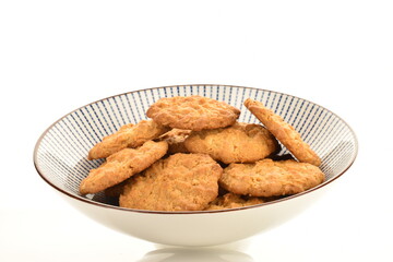 Several delicious torchetti cookies with oatmeal in a ceramic plate, close-up, isolated on white.