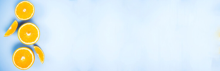 Banner for healthy concept. Flat lay. Beautiful background with oranges pieces of citrus on a blue background. Place for your design.