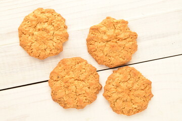 Several sweet torchetti cookies with oatmeal, close-up, on a white wooden table.