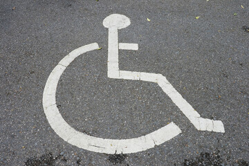 Wheelchair symbol in a disabled parking lot Old icons white on the street