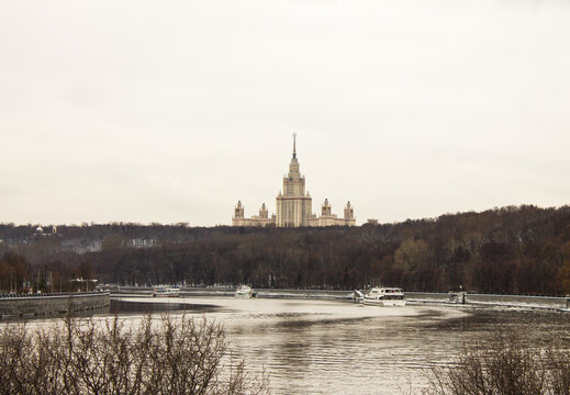 panoramic view of the historic MSU building and the Moscow River with bare trees on the bank on a cloudy winter day and space for copying