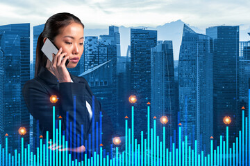 Attractive Asian businesswoman pensively processing conference call by phone to find financial solution for venture capital project. Hologram chart over Singapore city background
