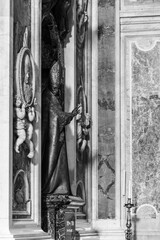 Black and white photo showing pope metal sculpture decorating wall inside Saint Peter Basilica