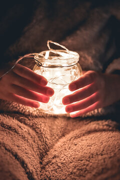 girl hands holding jar with lights. Selective focus