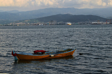 wooden yellow boat on the water of a small port in kocaeli, Turkey