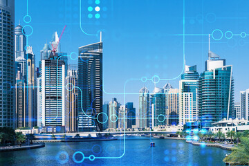 Fototapeta premium Skyscrapers of Dubai business downtown. International hub of trading and financial services. Technology theme icons hologram, concept of big data. Double exposure. Dubai Canal waterfront.