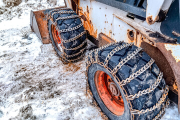 Old and rusty bulldozer with heavy duty black wheels wrapped in metal chains