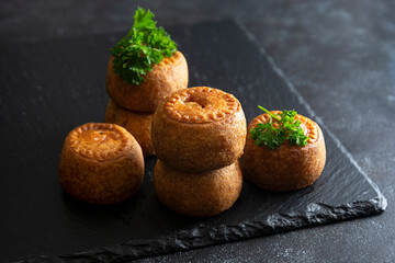 Meat pies isolated onblack board. Delicious mini pies. © Inga