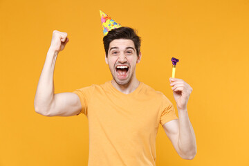 Young unshaved cute happy excited man 20s in basic t-shirt wearing birthday hat cone celebrating...