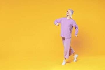 Fototapeta na wymiar Full length of young fun blonde caucasian woman 20s bob haircut wearing casual basic purple suit beanie hat standing holding hands crossed folded isolated on yellow color background studio portrait.