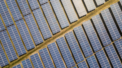 Aerial view of a new solar farm. Rows of modern photovoltaic solar panels farm. Renewable ecological source of energy from the sun. Aerial view.