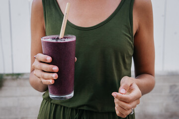 Woman holding a blueberry smoothie