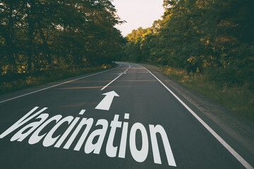 a sign on the road that a coronavirus vaccination is ahead