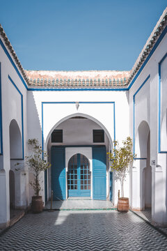 Inside Bahia Palace, one of the main attractions of Marrakesh. Courtyard with the doors in traditional Moroccan style. Typical arabic patio setting with blue sky.