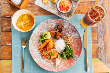 Southern delicious food of Thailand. Delicious and spicy meal on design plate with iced fresh orange juice topped with espresso. Fusion food with drink, have a good meal.