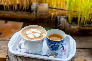 Hot coffee latte served with hot tea for morning refreshment.