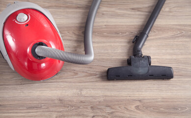 Vacuum cleaner on the wooden background.