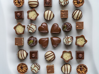Chocolate pralines variety assortment in white plate - top down view