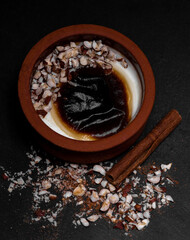 Turkish traditional dessert in earthenware casserole with cinnamon sticks and hazelnut; sutlac....