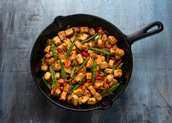 Vegetarian meat free mycoprotein pieces vegetable stir fry served in cast iron skillet frying pan